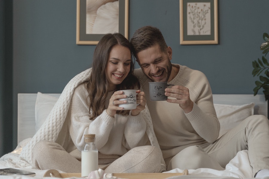 un couple prend un chocolat chaud pour se réchauffer à la maison