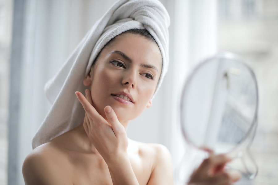 Une jeune femme utilise des soins anti-âge pour sa peau