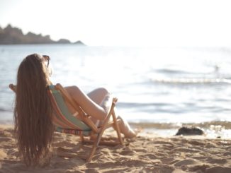 une femme bronze après avoir appliqué la crème solaire