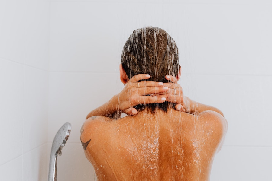 Une femme prend une douche froide le matin